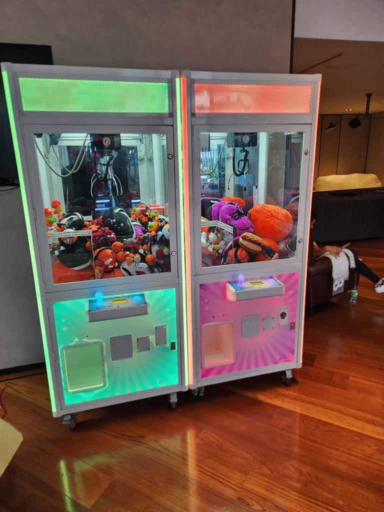 neon lighted arcade claw machine rental filled with plush prizes in Florida